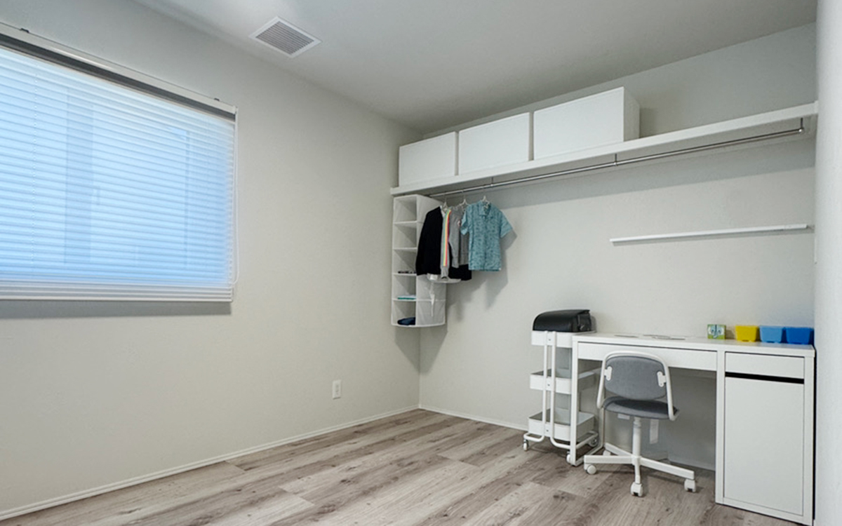 壁面収納とデスクを一体にしたレイアウト。収納扉が無いことで限られた空間でもすっきり広々。